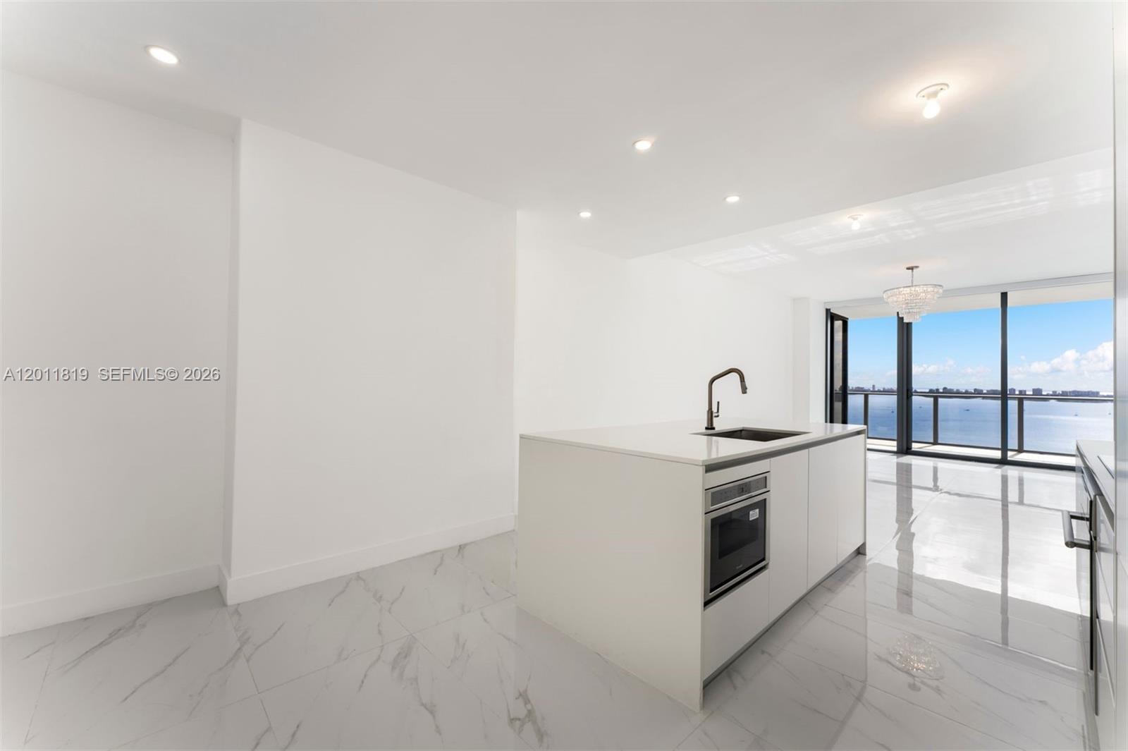 700 Northeast 24th Street, Unit 2504 Miami, FL 33137 - Photo 12 of 52 Modern chef’s kitchen equipped with custom Italian cabinetry, premium Miele appliances, integrated stone countertops, and a waterfall island perfect for entertaining.