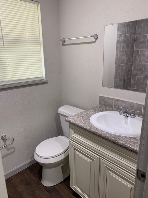 5244 Enyart Street Houston, TX 77021 - Photo 9 of 12 a bathroom with a granite countertop toilet a sink and a mirror