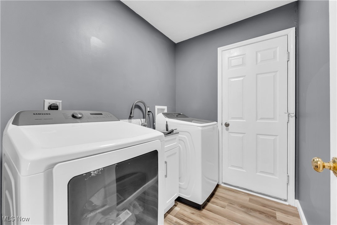 25861 Kennedy Ridge Road North Olmsted, OH 44070 - Photo 8 of 24 Washroom featuring washing machine and dryer, cabinet space, and light wood-type flooring