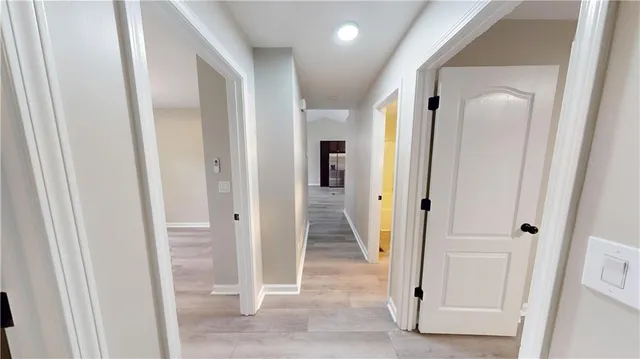 a view of a hallway with wooden floor and entryway