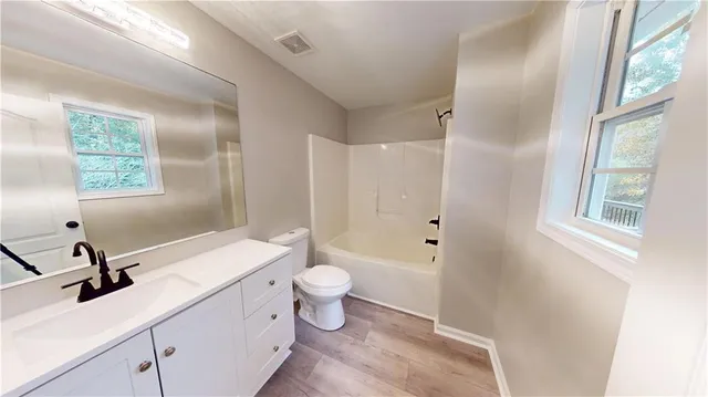 a bathroom with a sink a toilet and a mirror