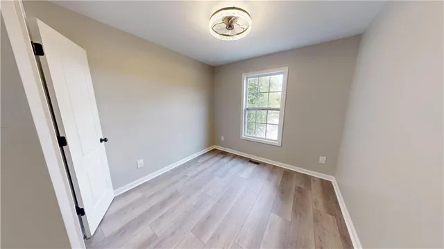 an empty room with wooden floor and a window