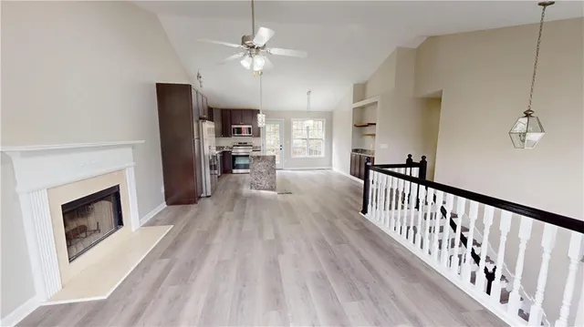 a view of a livingroom with furniture a fireplace chandeliers fan