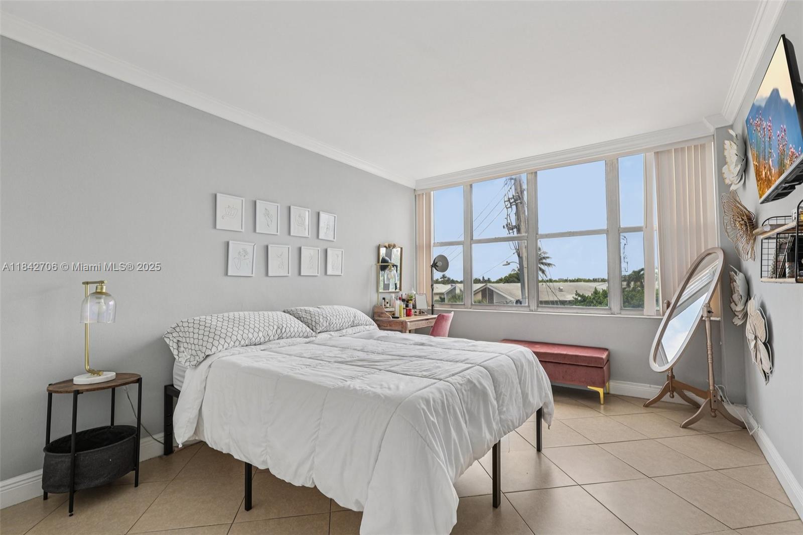 7441 Wayne Avenue, Unit 2B Miami Beach, FL 33141 - Photo 14 of 30 a bedroom with a bed a table and large window