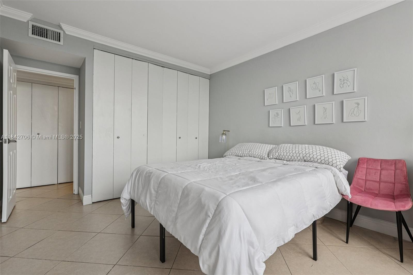 7441 Wayne Avenue, Unit 2B Miami Beach, FL 33141 - Photo 16 of 30 a bedroom with a bed and a chair