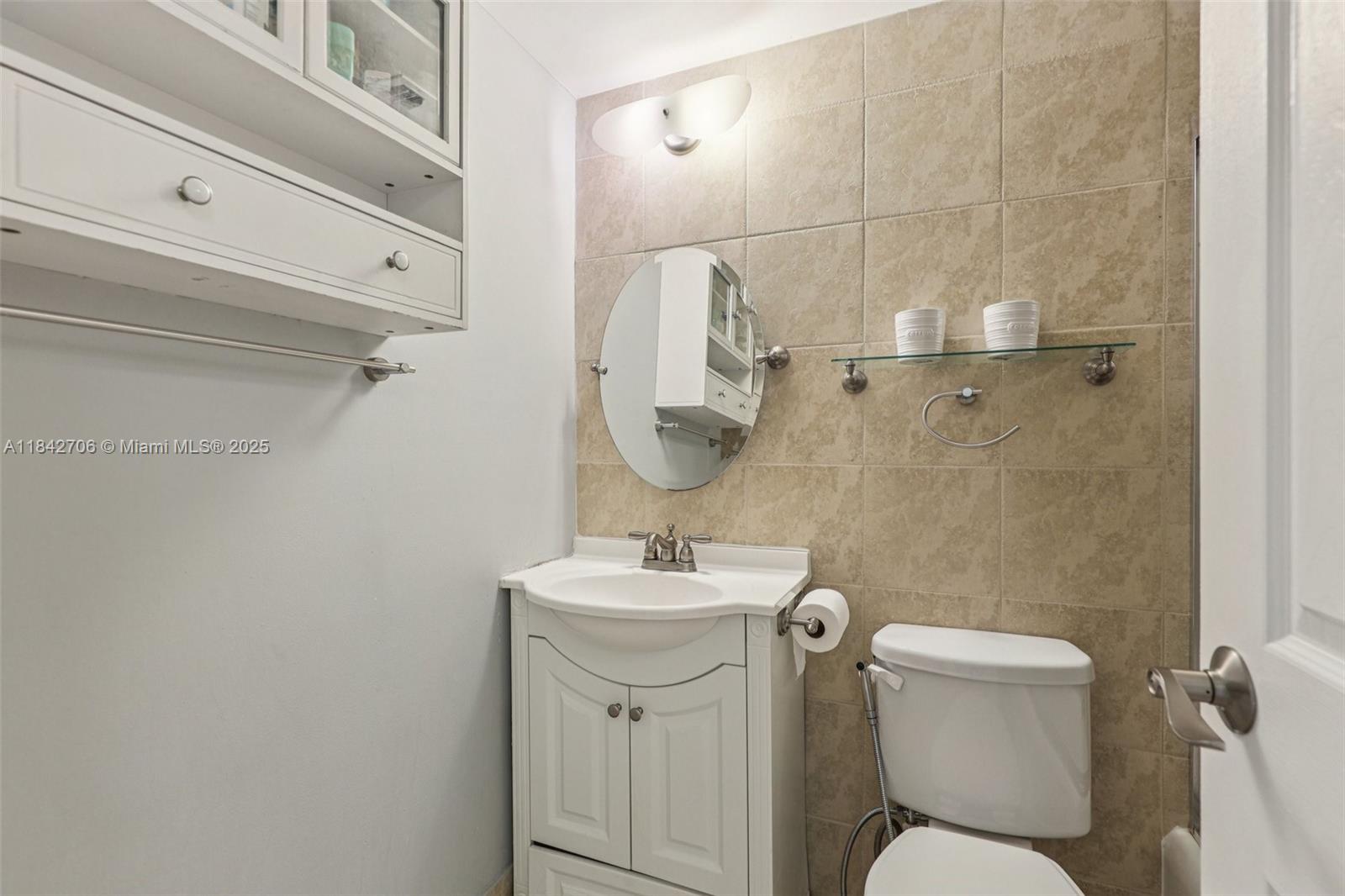 7441 Wayne Avenue, Unit 2B Miami Beach, FL 33141 - Photo 19 of 30 a bathroom with a sink toilet and a mirror