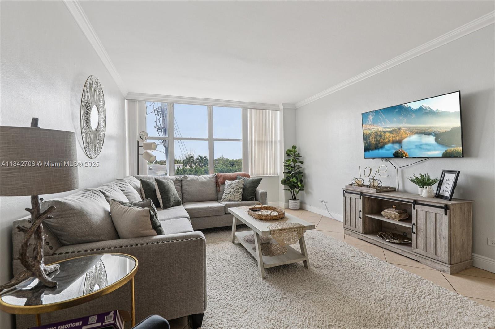 7441 Wayne Avenue, Unit 2B Miami Beach, FL 33141 - Photo 3 of 30 a living room with furniture a flat screen tv and a large window