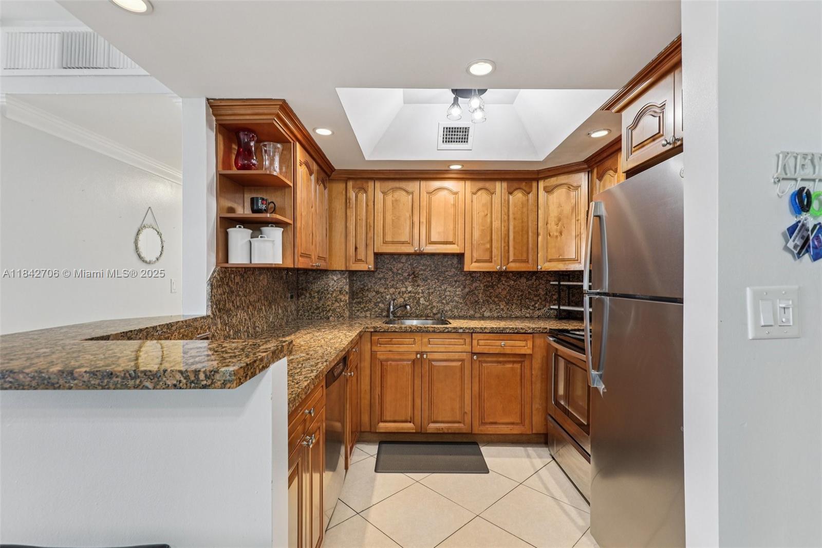 7441 Wayne Avenue, Unit 2B Miami Beach, FL 33141 - Photo 9 of 30 a kitchen with stainless steel appliances granite countertop a refrigerator and a sink