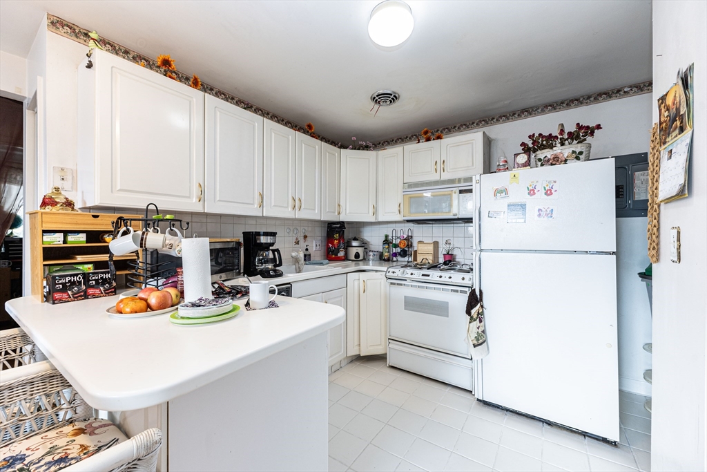 186 Lexington Street, Unit 8 Watertown, MA 02472 - Photo 2 of 22 a kitchen with a refrigerator a stove a sink and cabinets