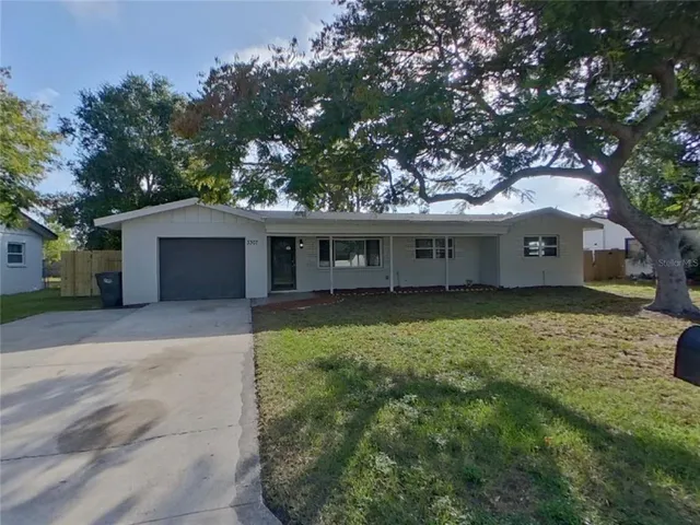 a view of a house with a garden and tree