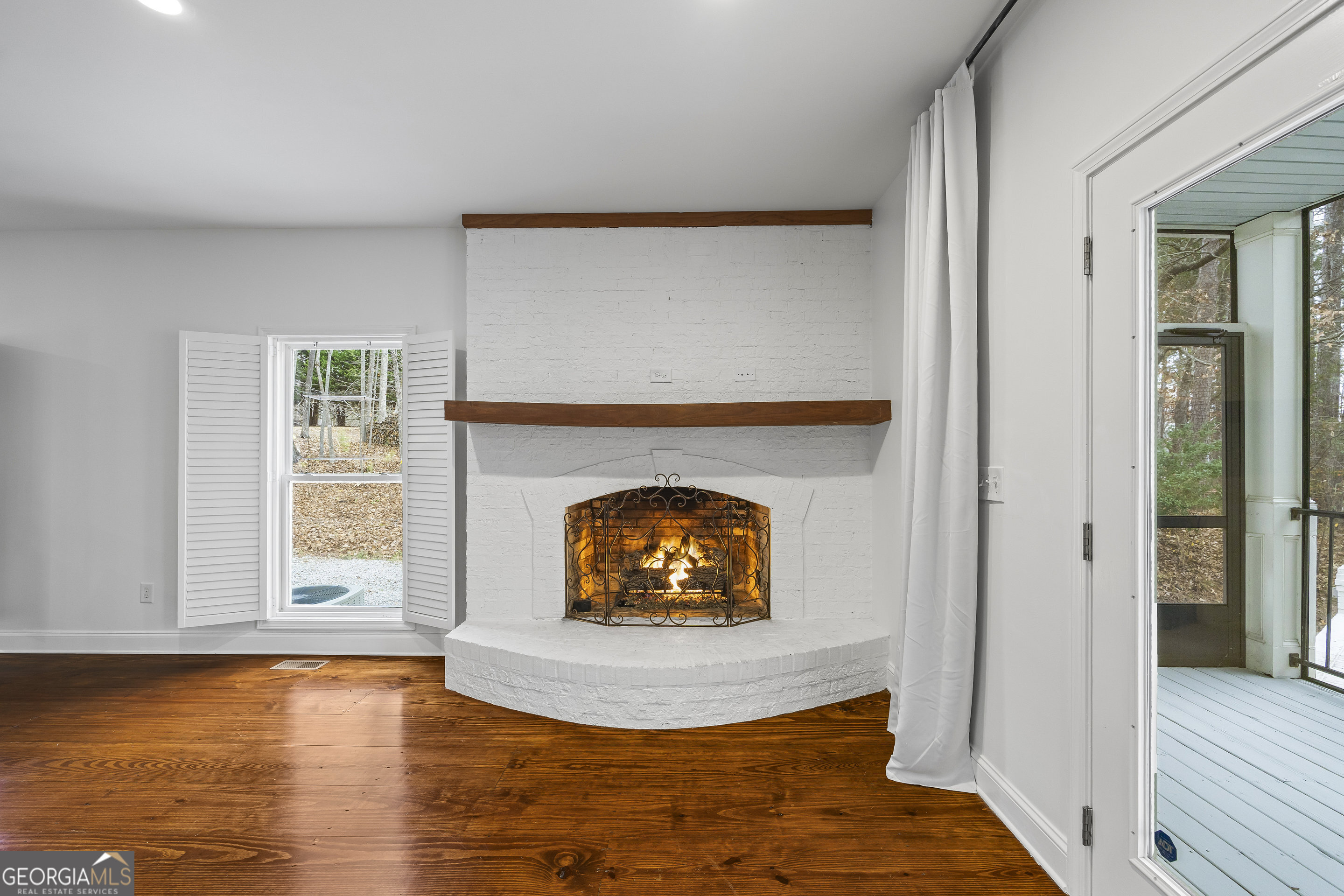 1270 Swords Road Greensboro, GA 30642 - Photo 13 of 44 a living room with a fireplace and a wooden floor