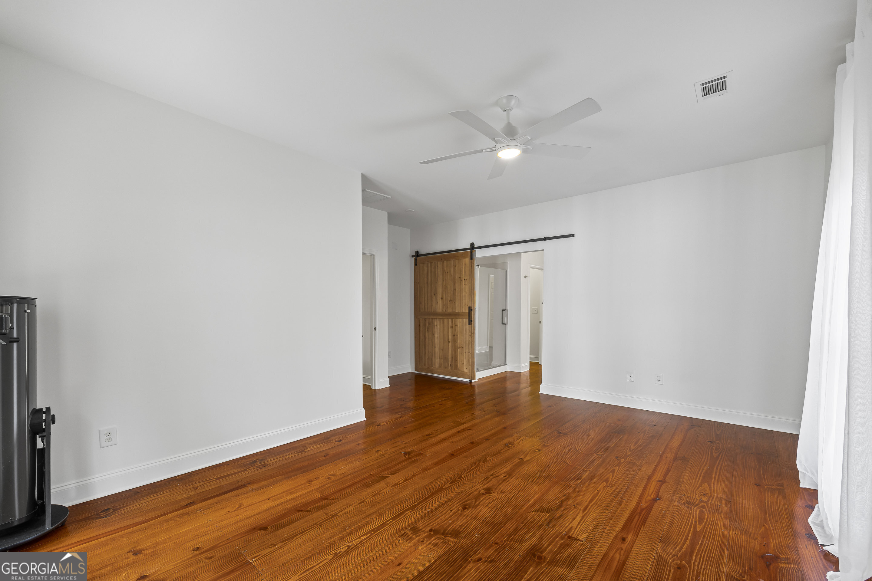1270 Swords Road Greensboro, GA 30642 - Photo 21 of 44 an empty room with wooden floor and windows