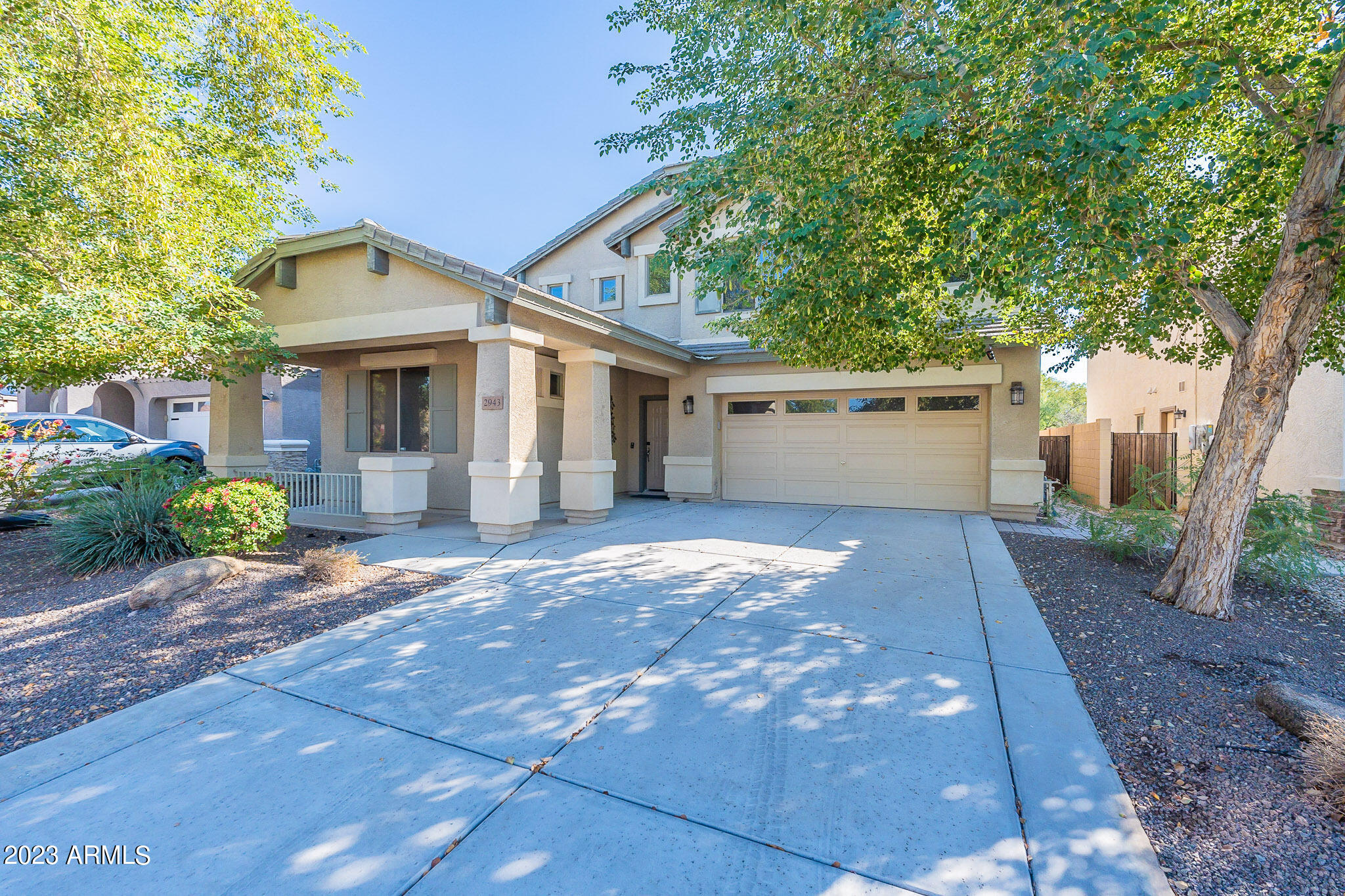 a view of a white house with a yard and large tree