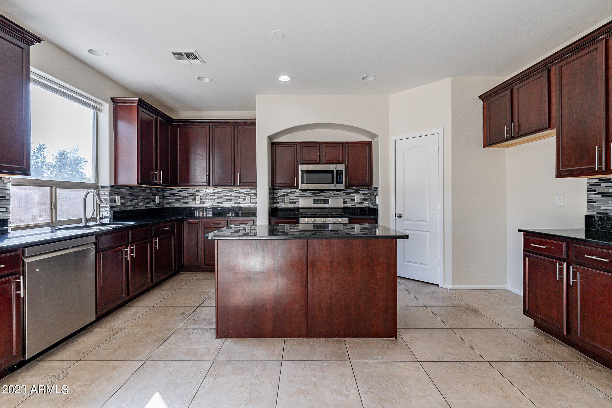 2943 East Quiet Hollow Lane Phoenix, AZ 85024 - Photo 14 of 65 a large kitchen with stainless steel appliances and a stove top oven