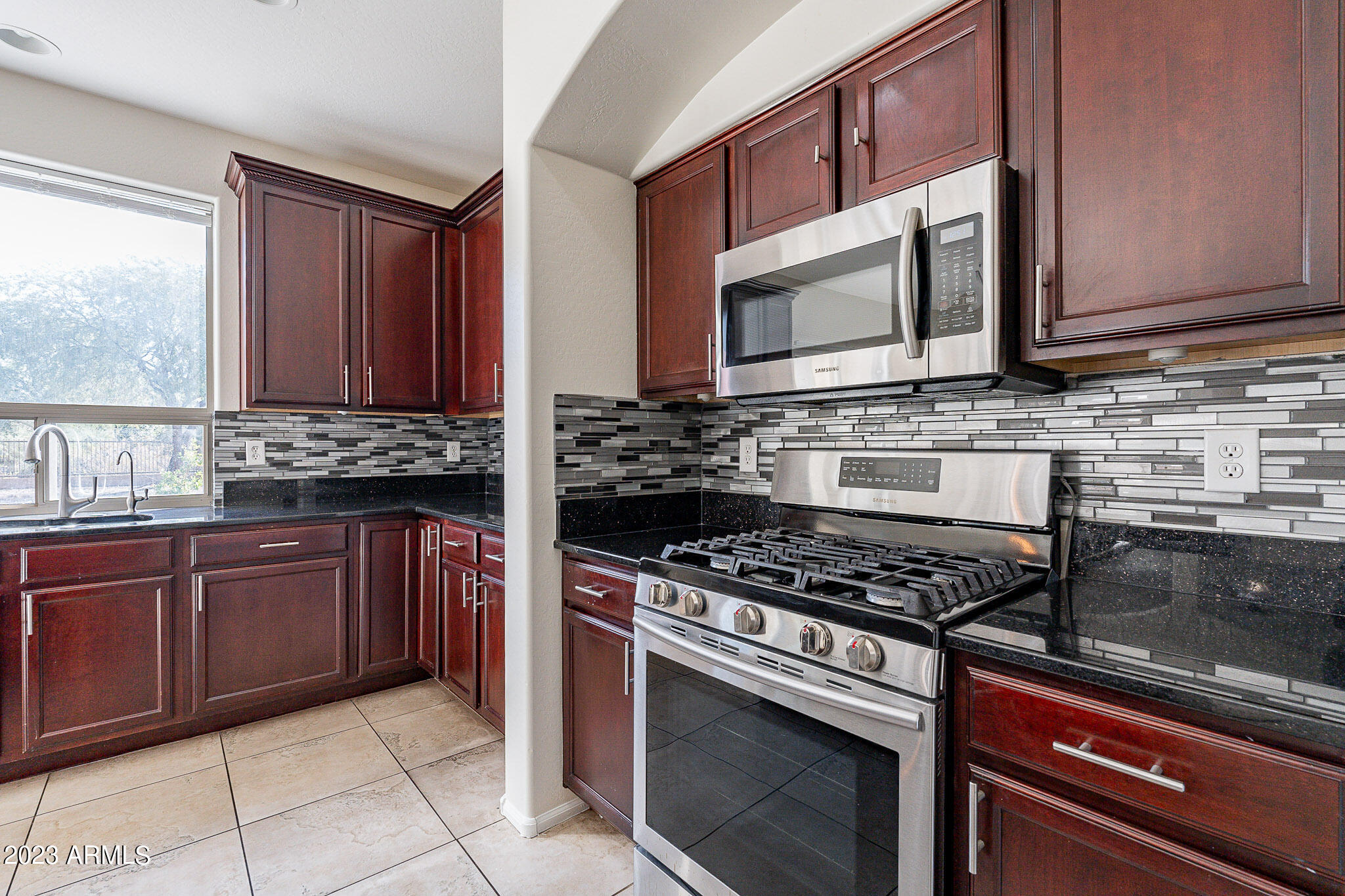 2943 East Quiet Hollow Lane Phoenix, AZ 85024 - Photo 16 of 65 a kitchen with stainless steel appliances granite countertop a stove microwave and cabinets