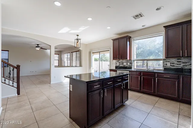 a bathroom with a granite countertop sink and a toilet