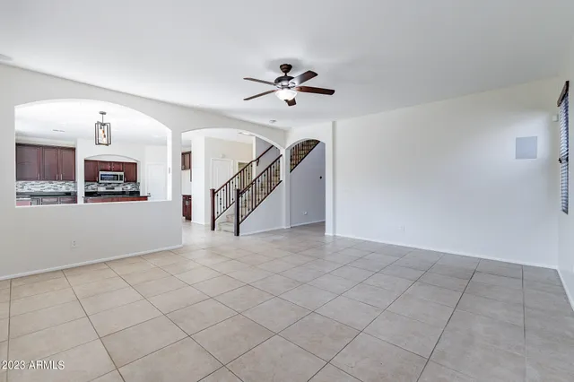 an empty room with windows and ceiling fan
