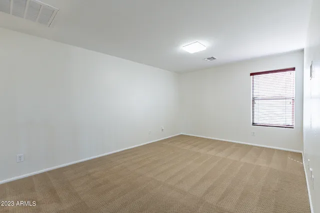 an empty room with a window and a fan