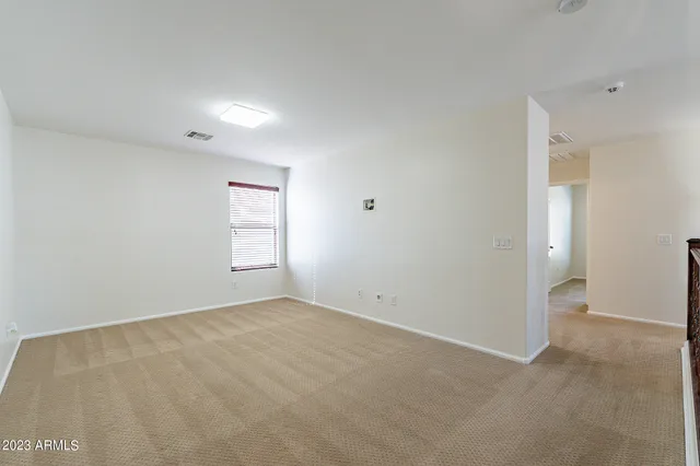 an empty room with closet and a ceiling fan
