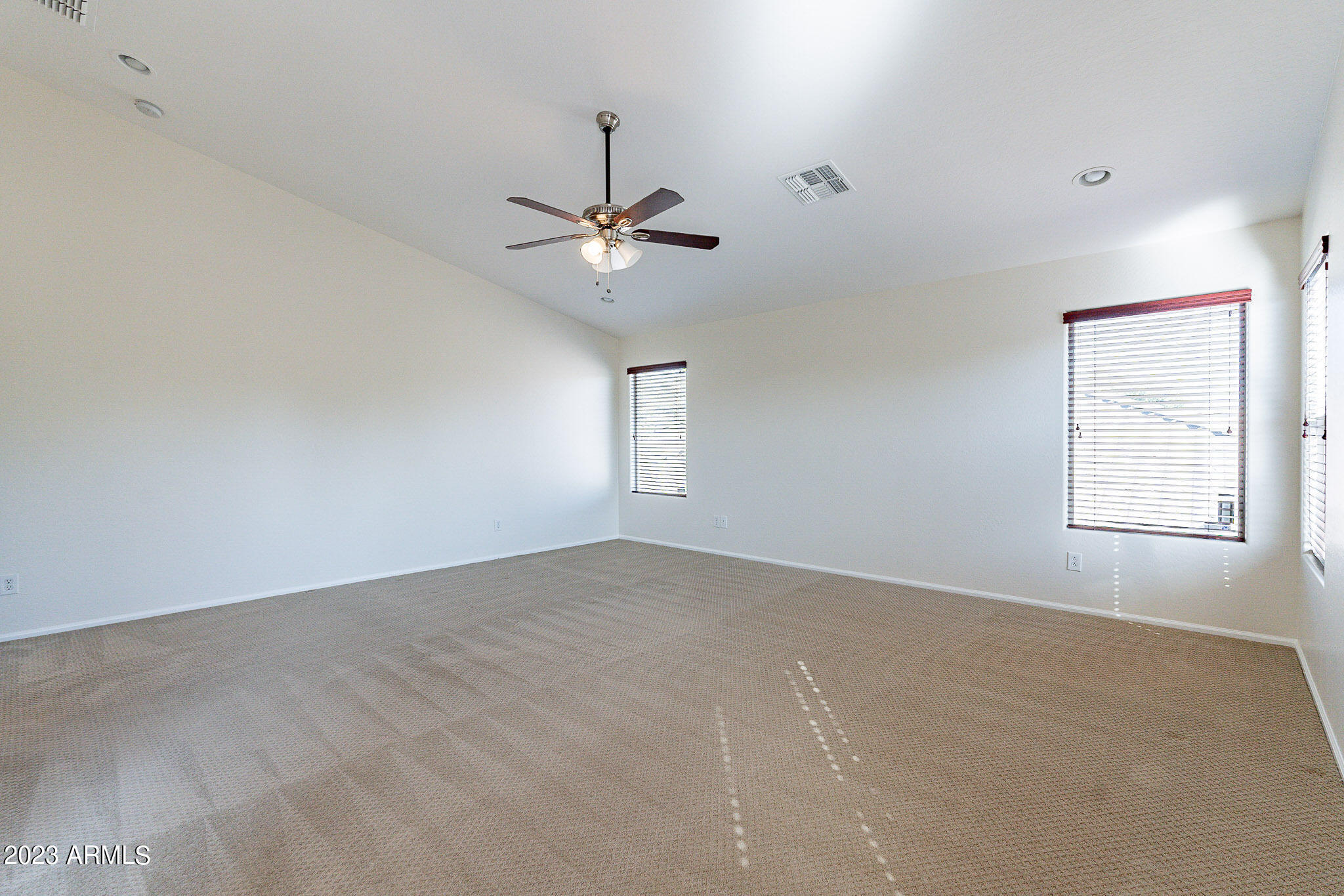 2943 East Quiet Hollow Lane Phoenix, AZ 85024 - Photo 40 of 65 an empty room with windows and ceiling fan