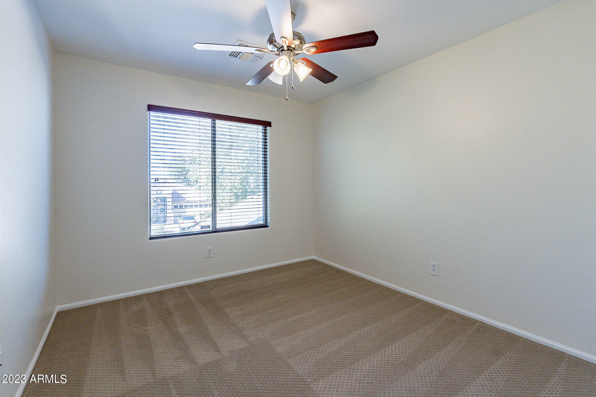 2943 East Quiet Hollow Lane Phoenix, AZ 85024 - Photo 48 of 65 an empty room with a window and a fan