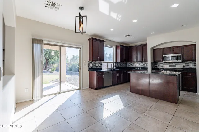 a large kitchen with stainless steel appliances and a stove top oven