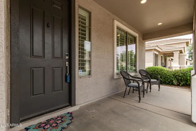 a view of a porch with chairs and potted plants