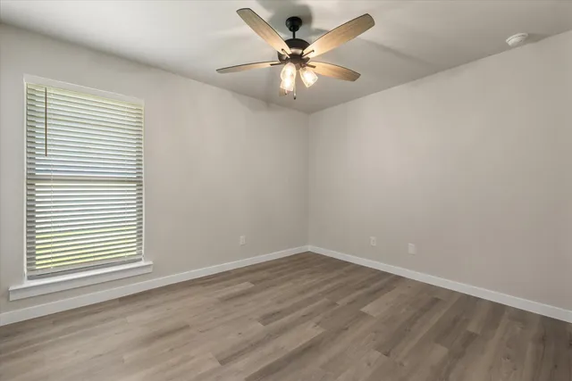 wooden floor in an empty room with a window