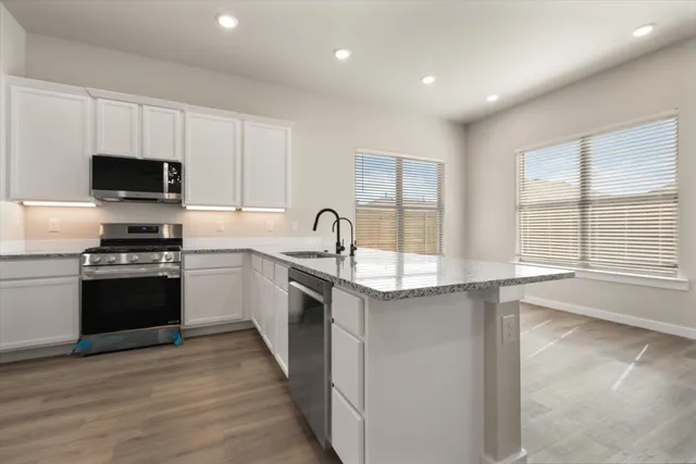 a kitchen with a sink stove top oven and refrigerator