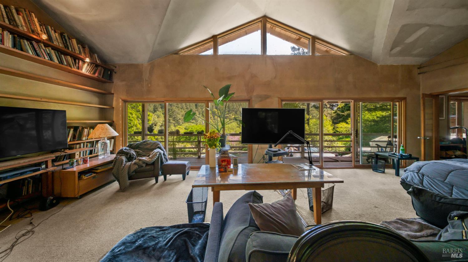 1 Alamo Way Lagunitas, CA 94938 - Photo 23 of 47 a living room with furniture a flat screen tv and a floor to ceiling window