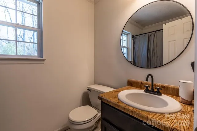 a bathroom with a toilet a sink and mirror