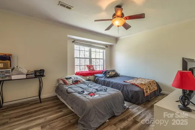 a bedroom with two beds and a chandelier