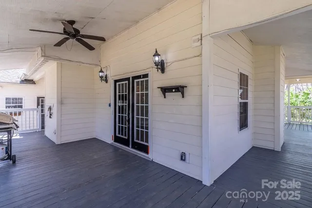 a view of a hallway with wooden floor and a ceiling fan