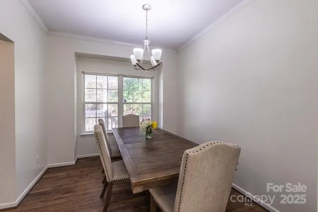 a view of a dining room with furniture a chandelier and wooden floor