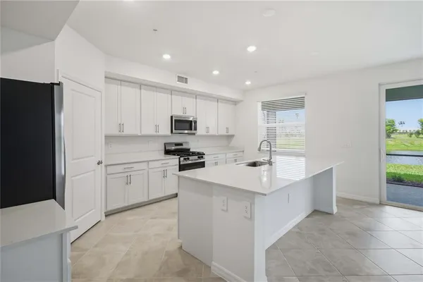 a kitchen with appliances a sink and a refrigerator