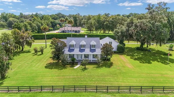 a front view of a house with yard and green space