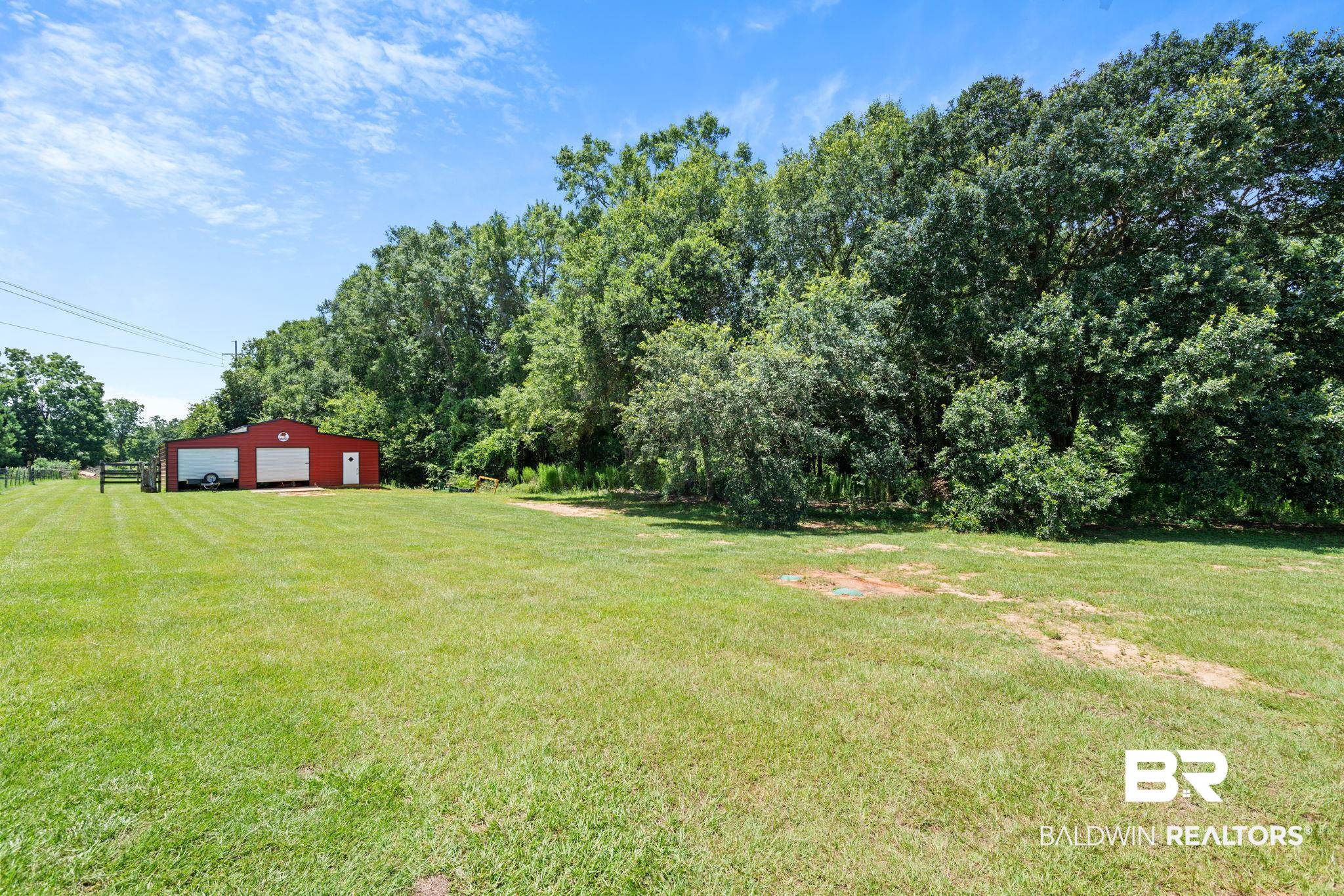 10703 South Ridge Drive Semmes, AL 36575 - Photo 5 of 37 View of green lawn with a garage, an outdoor structure, an outbuilding, and driveway