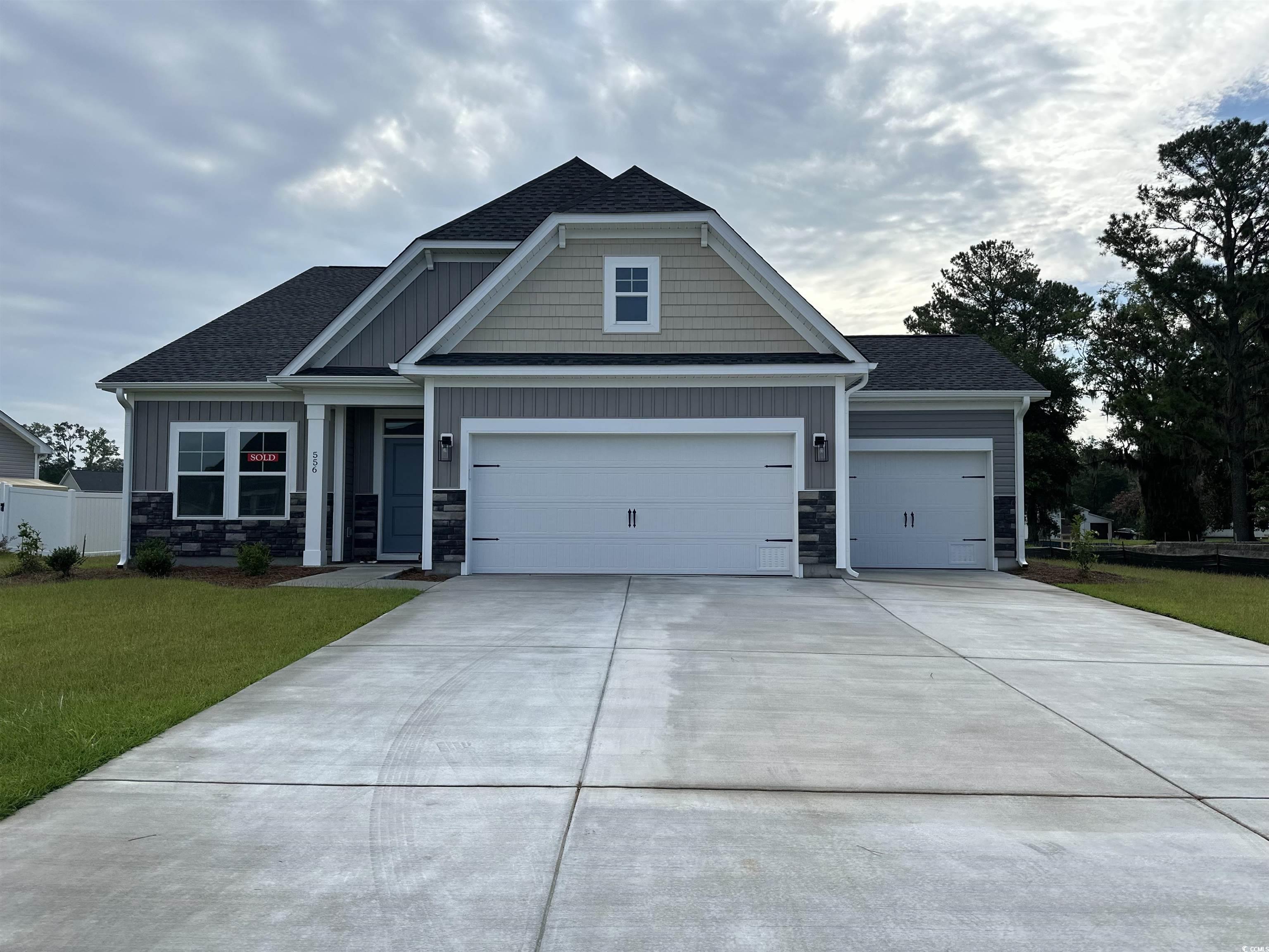 Craftsman-style home with stone siding, a shingled