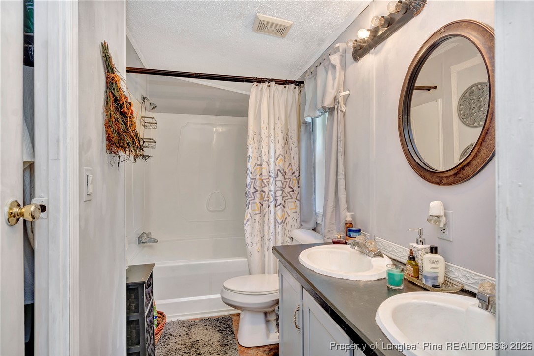 437 Paul Road Pembroke, NC 28372 - Photo 20 of 28 a bathroom with a granite countertop sink toilet and a mirror