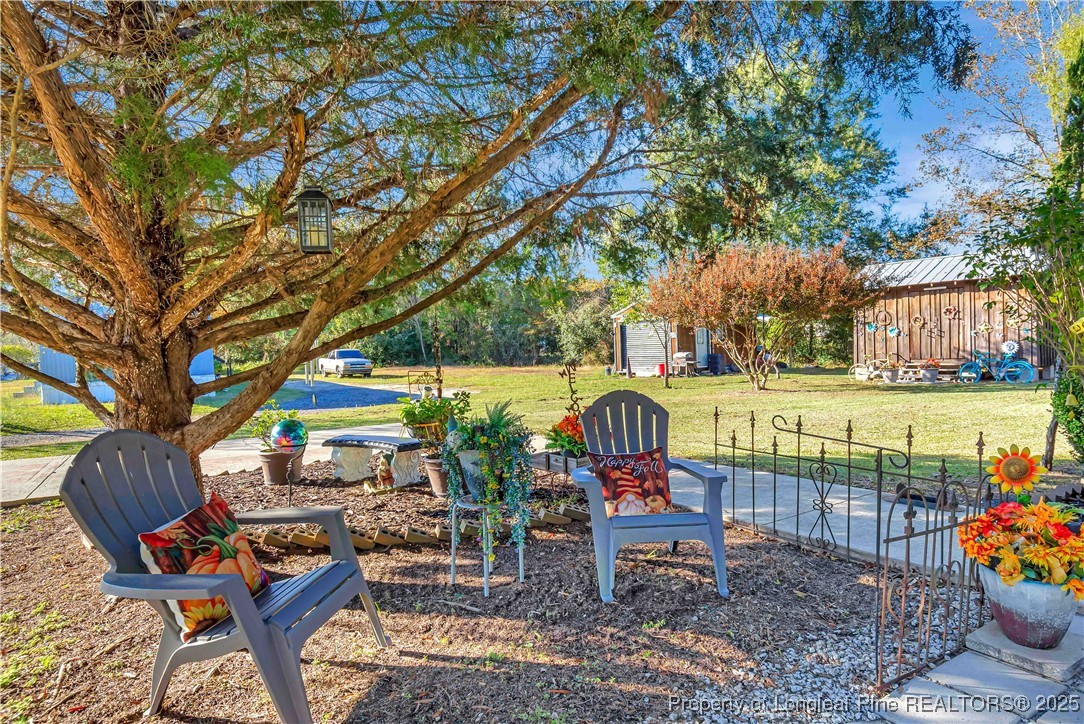 437 Paul Road Pembroke, NC 28372 - Photo 7 of 28 a view of a chairs and table in backyard