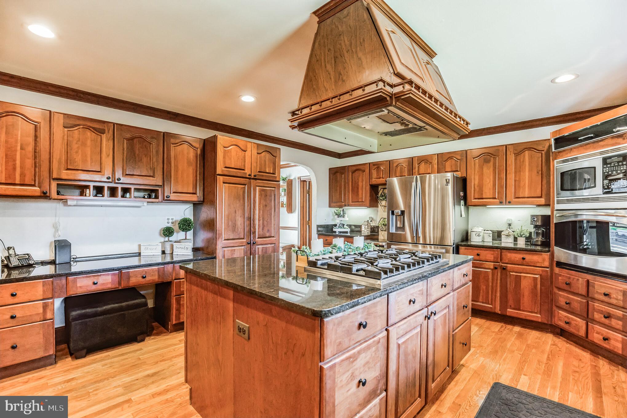 3310 Holland Cliffs Road Huntingtown, MD 20639 - Photo 15 of 40 a kitchen with stainless steel appliances granite countertop a stove a sink dishwasher and cabinets with wooden floor
