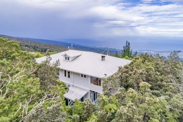 an aerial view of a house with a yard and lake view