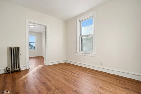an empty room with wooden floor and a window
