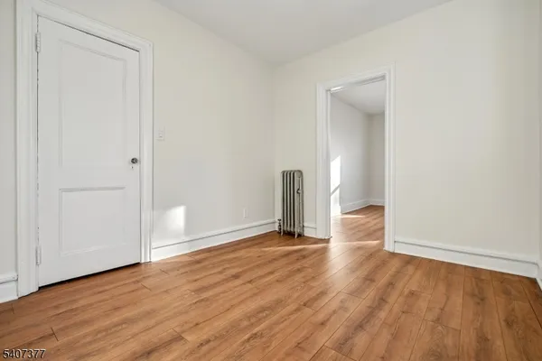 an empty room with wooden floor and closet