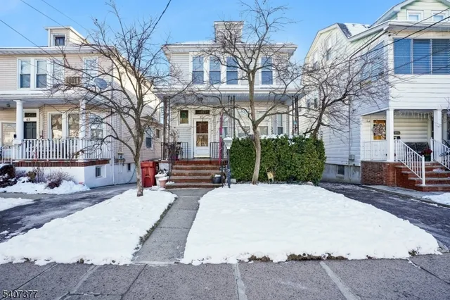 a front view of a house with a yard covered in snow