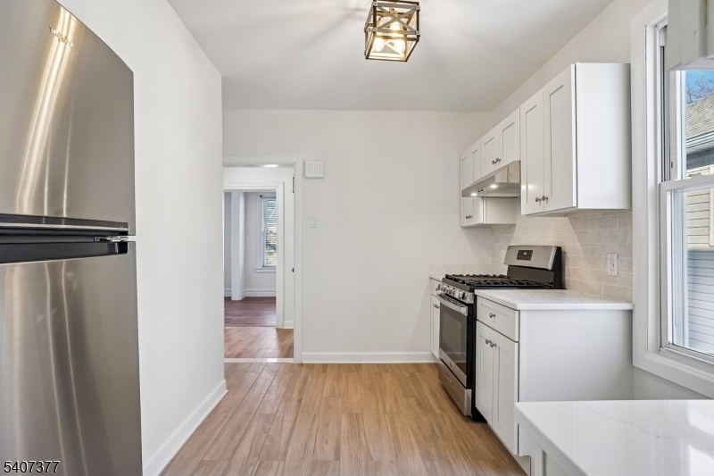 60 Union Avenue Nutley, NJ 07110 - Photo 2 of 17 a kitchen with a refrigerator a stove top oven and wooden floor