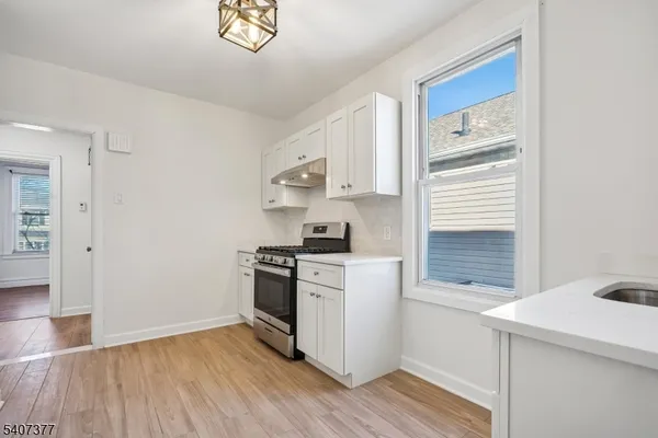 a kitchen with a stove cabinets and a wooden floor