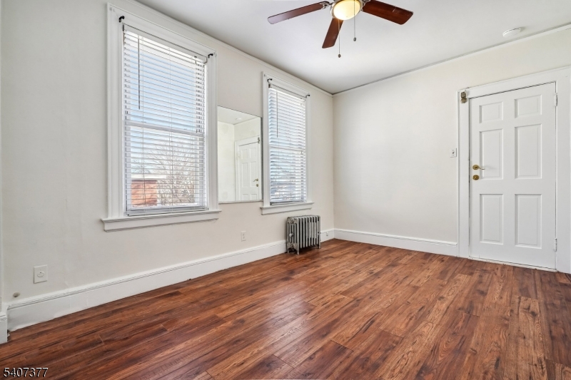 60 Union Avenue Nutley, NJ 07110 - Photo 5 of 17 an empty room with wooden floor chandelier fan and windows
