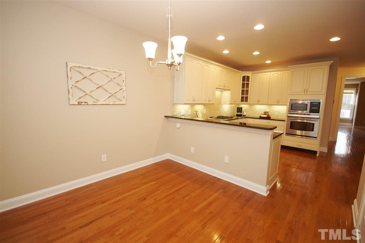 11032 Fair Chase Court Raleigh, NC 27617 - Photo 12 of 25 a kitchen with stainless steel appliances granite countertop a sink a stove top oven a counter space and cabinets