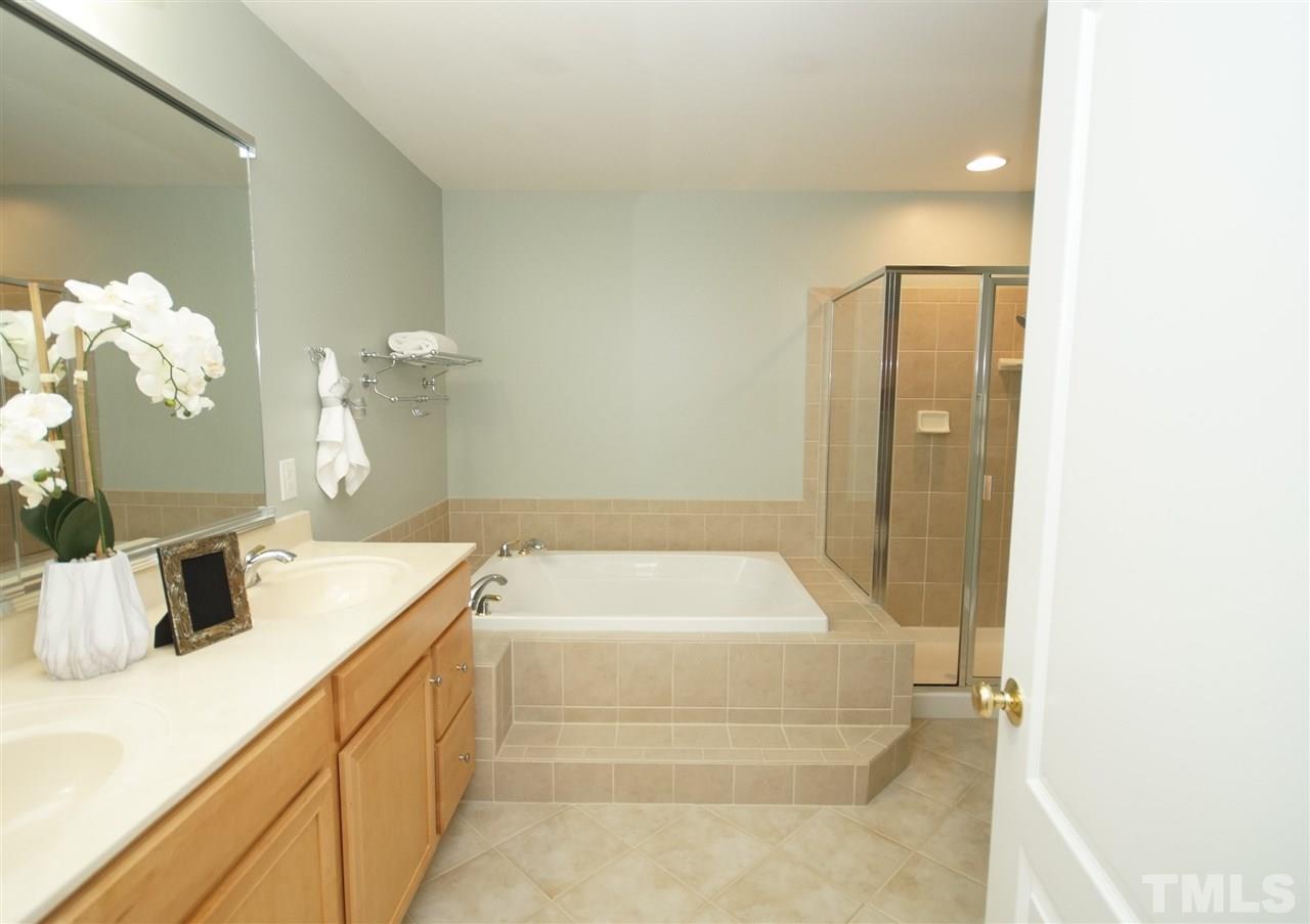 11032 Fair Chase Court Raleigh, NC 27617 - Photo 16 of 25 a bathroom with a tub sink and mirror